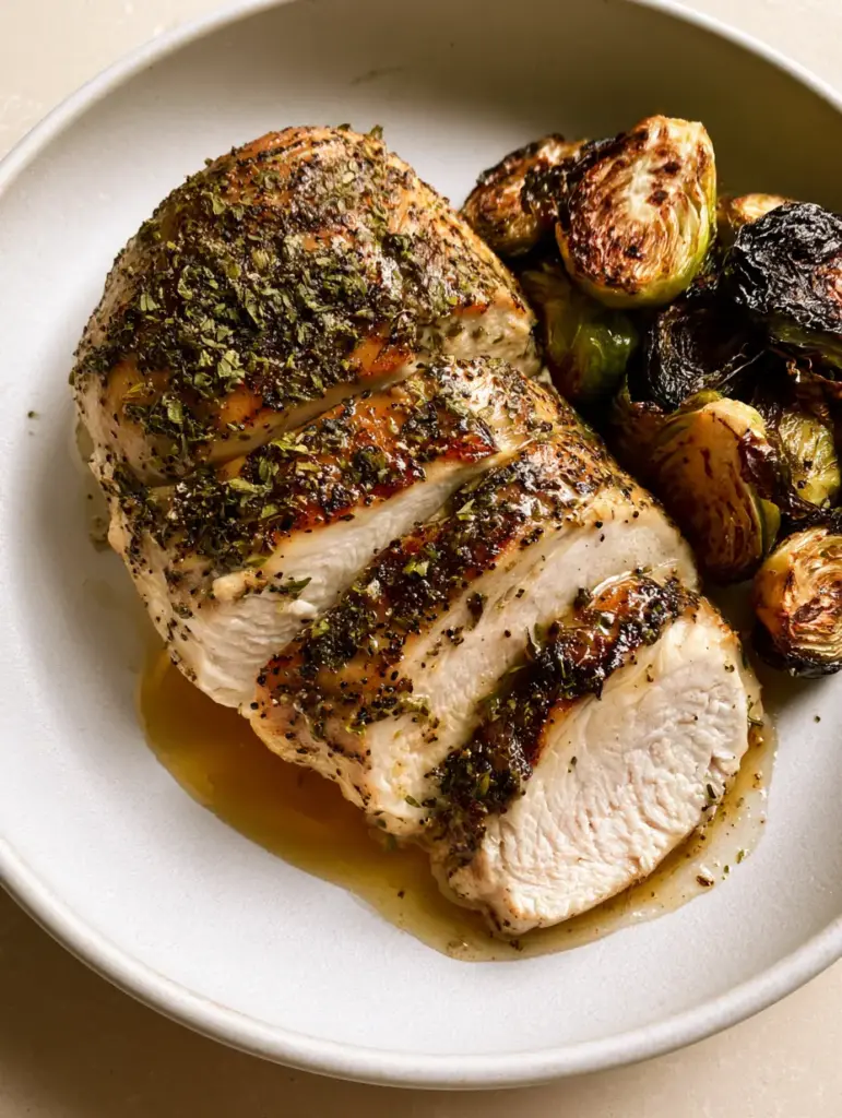 Halved Brussels sprouts with charred dark brown edges served next to honey-glazed Slow Cooker Chicken Breast.